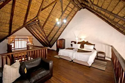 a bedroom with a bed and a couch in a room at Damani Lodge at Zebula Golf Estate and Spa in Warmbaths