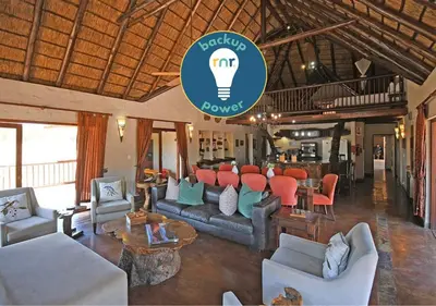 a living room with couches and a light bulb on the wall at Damani Lodge at Zebula Golf Estate and Spa in Warmbaths