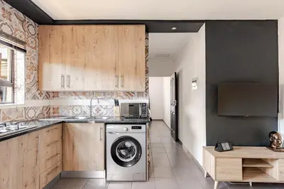 a kitchen with a washing machine in a kitchen at Amani Place Midrand in Midrand