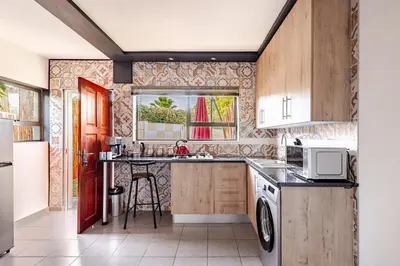 a kitchen with a sink and a stove top oven at Amani Place Midrand in Midrand