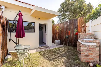 a patio with a table and chairs and an umbrella at Amani Place Midrand in Midrand