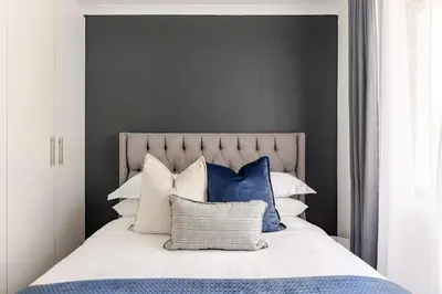 a bedroom with a bed with blue and white pillows at Amani Place Midrand in Midrand