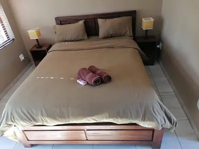 a bed with two rolled up towels on it at Lion and Cheetah Sanctuary in Cullinan
