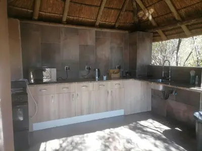a kitchen with wooden cabinets and a counter top at Lion and Cheetah Sanctuary in Cullinan