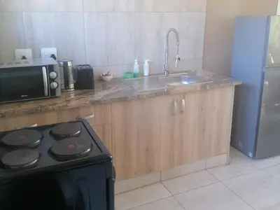 a kitchen with a stove top oven next to a sink at Lion and Cheetah Sanctuary in Cullinan