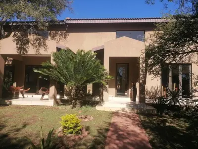 a house with a palm tree in front of it at Lion and Cheetah Sanctuary in Cullinan