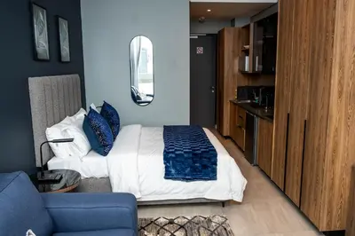 a bedroom with a bed and a blue wall at Triple M Luxury in Vosburg