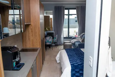 a hotel room with a bed and a living room at Triple M Luxury in Vosburg