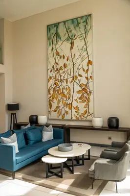 a living room with a blue couch and a painting at Triple M Luxury in Vosburg