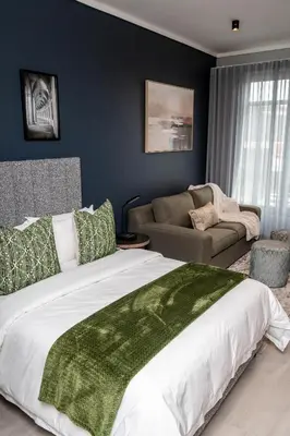 a bedroom with a large bed and a couch at Triple M Luxury in Vosburg