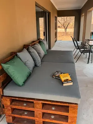 a bed with pillows and a book on it at Dung Beetle Bush Villa in Marloth Park