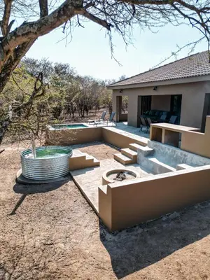 a backyard with a hot tub and a house at Dung Beetle Bush Villa in Marloth Park