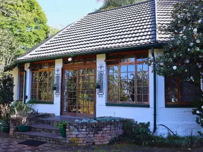 a small white house with windows and a staircase at Glory Hill Lodge in White River