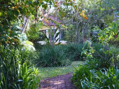 a garden with a brick path in front of a house at Glory Hill Lodge in White River