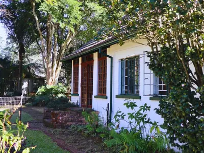 a small white house with trees in the yard at Glory Hill Lodge in White River