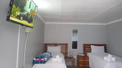 a room with two beds and a flat screen tv at The Croc Backpackers in Springs