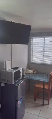a kitchen with a microwave and a table in it at The Croc Backpackers in Springs