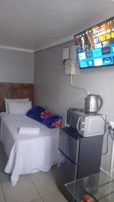a bedroom with a bed and a tv on the wall at The Croc Backpackers in Springs