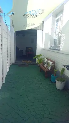 a patio with a bench and plants on a house at The Croc Backpackers in Springs