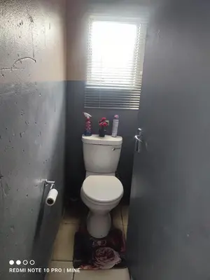 a bathroom with a white toilet with a window at The Croc Backpackers in Springs