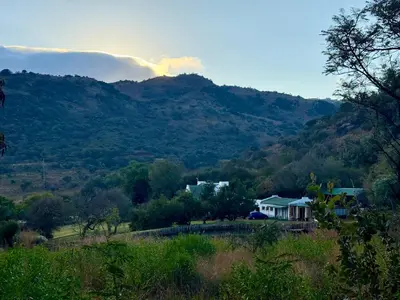 a house on a hill with mountains in the background at La Ronel Guest Farm in Roossenekal