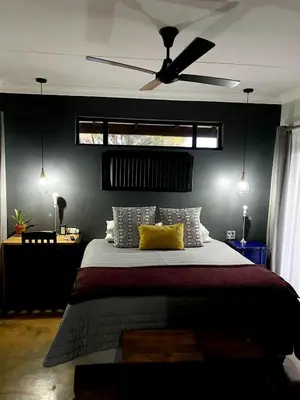 a bedroom with a bed with a ceiling fan at Phatt Olive BnB in Middelburg