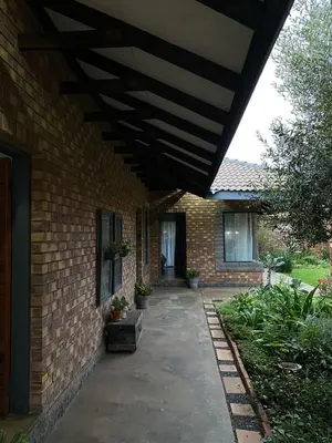 a brick house with awning over a patio at Phatt Olive BnB in Middelburg