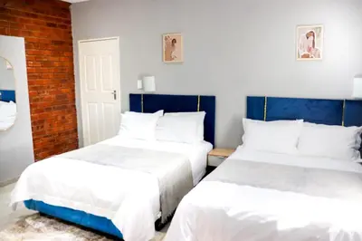 two beds sitting next to each other in a bedroom at Glowti Event & Guest House in Centurion