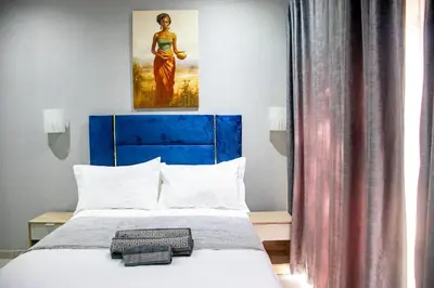 a bed with a blue headboard in a room at Glowti Event & Guest House in Centurion