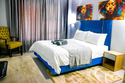 a bedroom with a bed with a blue headboard at Glowti Event & Guest House in Centurion