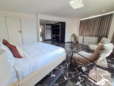 a bedroom with a bed and two chairs in it at Pent Lucius - 3 bedroom Penthouse in Pretoria