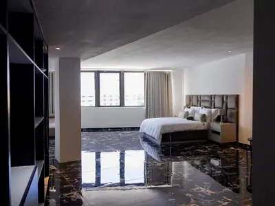 a bedroom with a bed and a floor covered in water at Pent Lucius - 3 bedroom Penthouse in Pretoria
