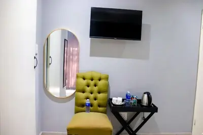 a yellow chair in a room with a mirror at Glowti Guest House in Centurion