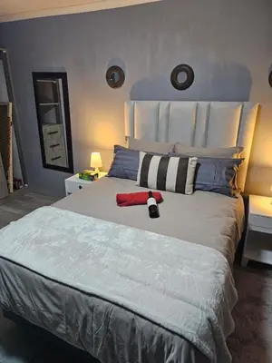 a bedroom with a large bed with a red towel on it at Beautiful apartment in Witbank