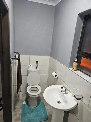 a bathroom with a white toilet and a sink at Beautiful apartment in Witbank