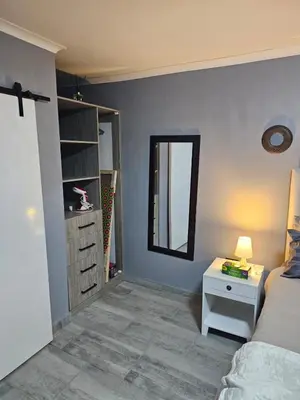 a bedroom with a bed and a table and a mirror at Beautiful apartment in Witbank