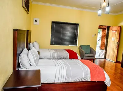 a bedroom with a large bed and a chair at Twin Bed Room in Steelpoort