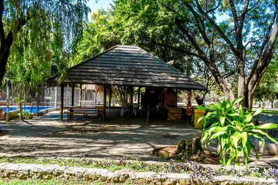 a pavilion in a park with a bench and trees at Twin Bed Room in Steelpoort