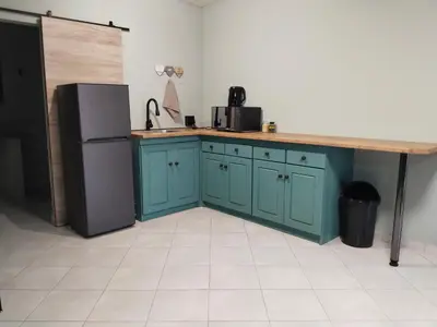 a kitchen with blue cabinets and a counter and a refrigerator at Duikertjie in Groblersdal