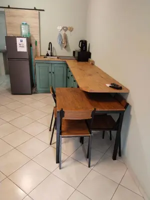 a kitchen with a wooden table and chairs and a refrigerator at Duikertjie in Groblersdal