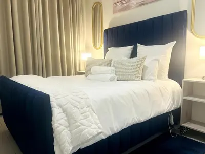a bedroom with a large bed with white sheets and pillows at Cozy Carlswald EXcape in Midrand
