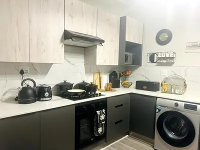 a kitchen with a stove and a washing machine at Cozy Carlswald EXcape in Midrand