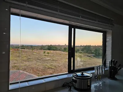 a kitchen window with a view of a field at Outerspaces Farmhouse Retreat