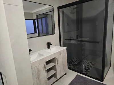 a bathroom with a sink and a shower at Outerspaces Farmhouse Retreat