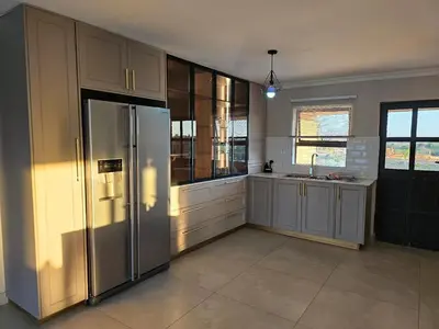 a large kitchen with a stainless steel refrigerator at Outerspaces Farmhouse Retreat