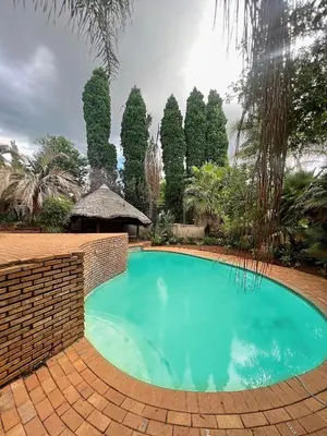 a swimming pool with a brick wall around it at Bugera's Palace in Pretoria