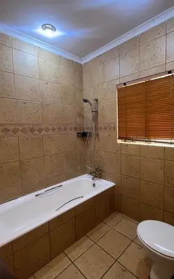 a bathroom with a bath tub and a toilet at Bugera's Palace in Pretoria