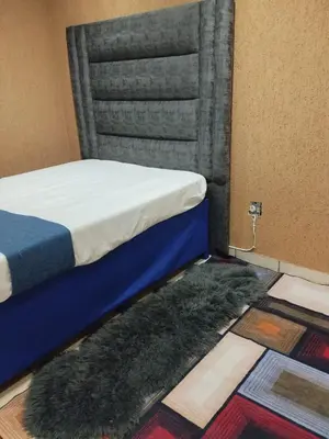 a bedroom with a bed and two rugs on the floor at Queen Guest House in Pretoria