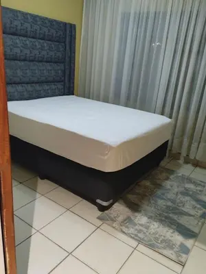 a bed sitting in a room next to a window at Queen Guest House in Pretoria