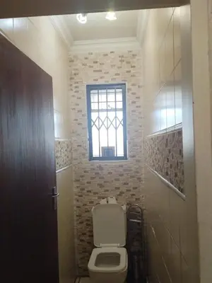 a bathroom with a toilet and a window at Queen Guest House in Pretoria